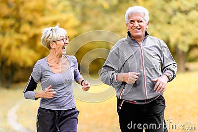 Smiling senior couple jogging in the park Stock Photo
