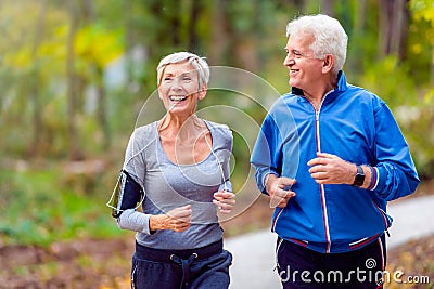 Smiling senior couple jogging in the park Stock Photo