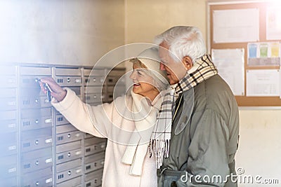 Senior couple unlocking apartment mailbox Stock Photo