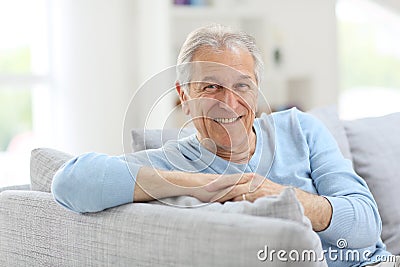 Smiling senior man on sofa Stock Photo