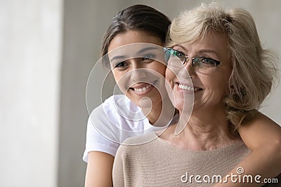 Smiling mature mother and adult daughter look in distance dreaming Stock Photo