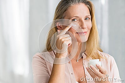 Woman applying anti aging lotion on face Stock Photo