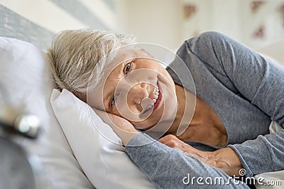 Senior woman resting on bed Stock Photo