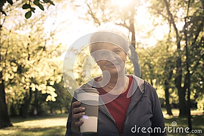 Senior woman in sports clothing standing in park looking Stock Photo