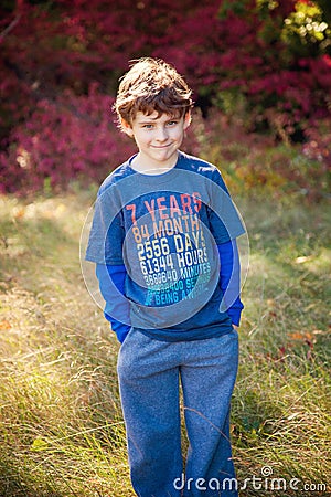 Smiling seven year old wearing 7 year old shirt in field Stock Photo