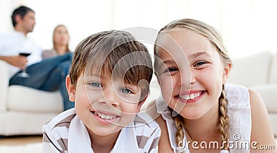 Smiling siblings lying on the floor Stock Photo