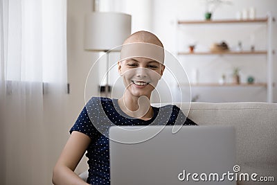 Smiling sick bald young woman relax browsing laptop Stock Photo