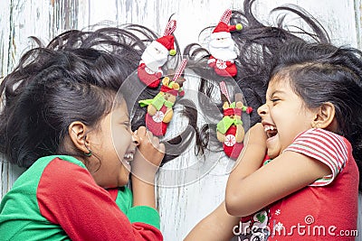 Smiling sisters decorating their hair with Christmas decorations Stock Photo