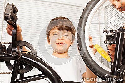 Smiling six years old boy repairing his bicycle Stock Photo