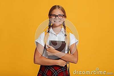Smiling smart european teenager female student in glasses with pigtails hold books Stock Photo