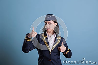 Smiling stewardess showing two thumbs up gesture Stock Photo