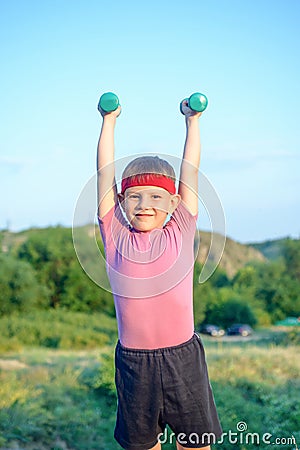 Smiling Strong Boy Raising Two Dumbbells Stock Photo