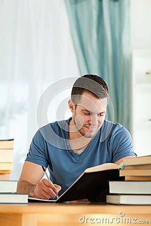 Smiling student reviewing his subject material Stock Photo