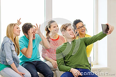 Smiling students making picture with tablet pc Stock Photo