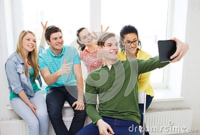 Smiling students making picture with tablet pc Stock Photo