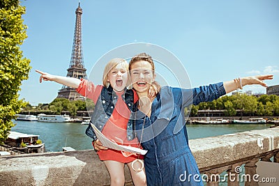 Smiling stylish mother and child tourists with map rejoicing Stock Photo