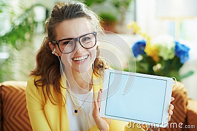 Smiling stylish woman with headphones showing tablet PC Stock Photo