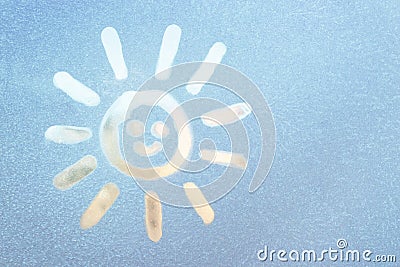 Smiling sun painted on a frozen window, winter fun, season change and hope concept Stock Photo