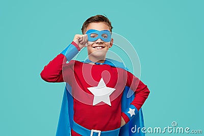 Smiling superhero kid in costume in studio Stock Photo