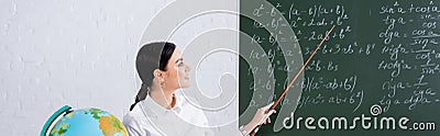 Smiling teacher pointing at mathematic equations Stock Photo