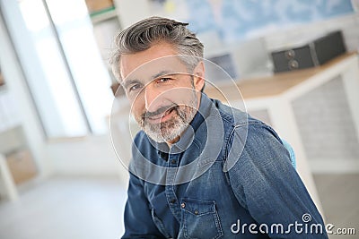 Smiling teacher sitting at desk Stock Photo