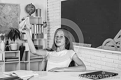 smiling teen girl play with paper plane in school classroom, childhood Stock Photo