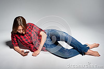 Smiling teen girl sitting barefooted at floor smiling at camera Stock Photo