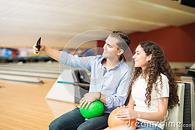 Teenage Couple Taking Selfportrait Using Smartphone In Bowling C Stock Photo