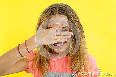 Smiling teenage girl embracing her eyes with fingers Stock Photo