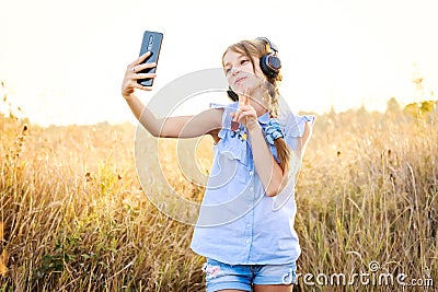 Teenage girl with headphones taking cute selfie Stock Photo