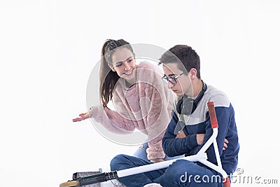 Smiling teenage girl tries to cheer up an angry boy Stock Photo