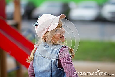 A smiling teenage girl with a slightly disheveled hairdo looks back. Stock Photo