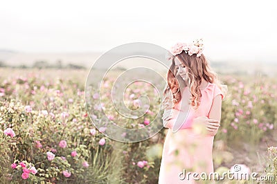 Smiling teenage girl standing in rose garden Stock Photo