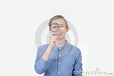 Smiling tennager with magnifying glass on white background. Curious Teenager with Magnifying Glass Isolated on the White Stock Photo
