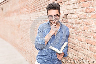 Smiling and thoughtful casual man reading a book Stock Photo