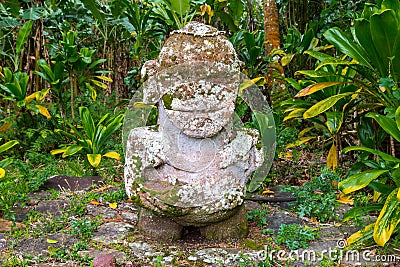 Smiling tiki. Carved stone Polynesian sacred idol statue. Raivavae island, Astral islands, French Polynesia, Oceania. Stock Photo