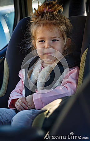 Smiling toddler girl buckled into her car seat Stock Photo