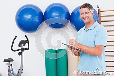 Smiling trainer writing on clipboard Stock Photo