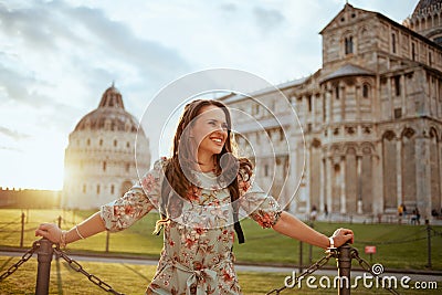 Smiling trendy woman in floral dress enjoying promenade Stock Photo