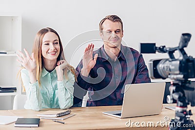Smiling video bloggers recording vlog and waving hands Stock Photo