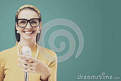 Smiling vintage style woman standing in front of a microphone Stock Photo