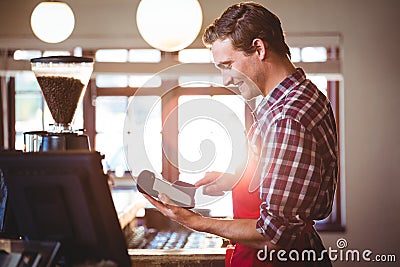 Smiling waiter using credit card machine Stock Photo