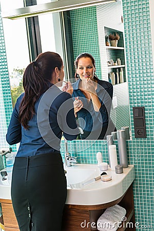 Smiling woman bathroom applying lipstick mirror businesswoman Stock Photo