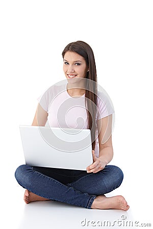 Smiling woman browsing internet on floor Stock Photo