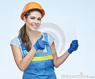 Smiling woman builder holding white sign board with thumb up. Stock Photo