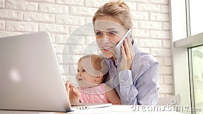 Smiling woman with child speaking phone. Happy business mother working at home Stock Photo