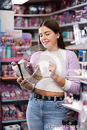 Smiling woman chooses a gift set for someone in cosmetics store Stock Photo