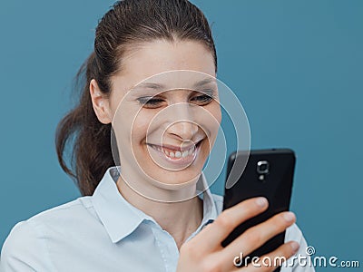 Smiling woman connecting with her smartphone Stock Photo