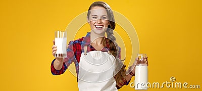 Smiling woman cook giving glass of homemade fresh raw milk Stock Photo