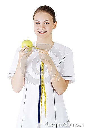 Smiling woman doctor with a green apple and measuring tape. Stock Photo